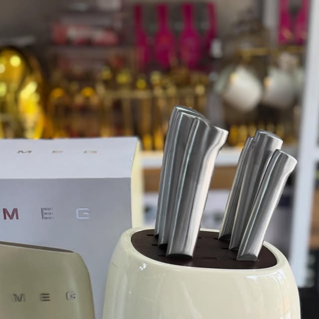 2 likes, 0 comments - the_classic_kitchens_and_more on June 17, 2026: "SMEG 6-Piece Knife Block Set 🔪

 Cream colour⚪️

Iconic style. Razor-sharp precision. The last knife set you’ll ever need.

•6-Piece Full Set – Chef, bread, utility & steak knives. All your cutting tasks covered 
•Signature SMEG Retro Design – Glossy cream body  with wood-grain base. Statement piece for your counter 
•Premium Stainless Steel Blades – Sharp, durable & r...